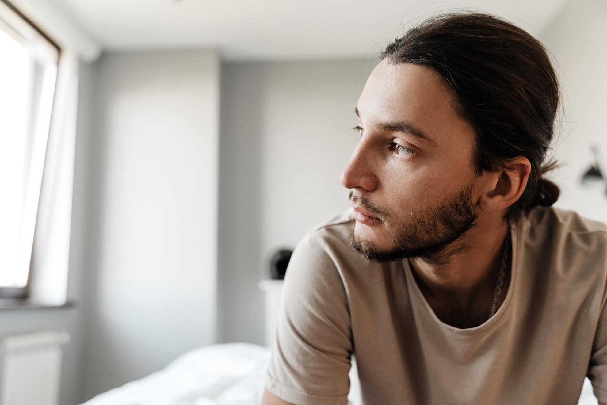 Young man in depression sitting on bed